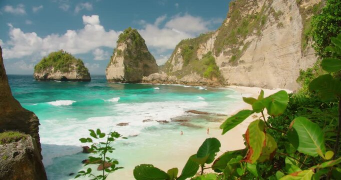 Turquoise waves wash onto the white sand shore of Diamond Beach in Nusa Penida Bali