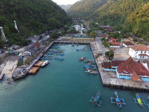 Aerial Drone View of Traditional Fishing Boats Moored at Sadeng Fishing Port During Sunset, Yogyakarta, Indonesia