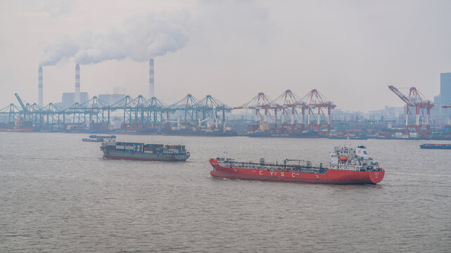 Port of Shanghai panorama with container vessel in the port and several container cranes and smog in Shanghai China