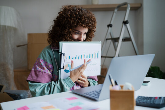 Woman analyzing data and report while working from home office