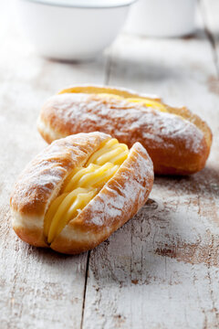 Two Bismarck doughnuts filled with pudding, close-up