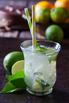 Fruit spritzer of limes in a glass with drinking straws