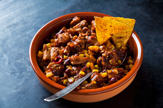 Vegetarian Chili with soy meat cut into strips and tortilla chips in earthenware dish