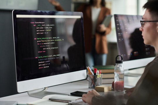 Male developer writes computer script during university class
