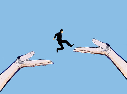 Small businessman jumps between large hands in blue space