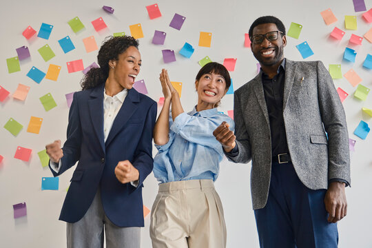 Smiling colleagues celebrate business success at the office