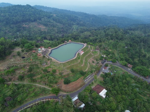 Aerial drone footage of Embung Nglanggeran, a scenic artificial reservoir located in the Ancient Nglanggeran Volcano area, Yogyakarta, Indonesia.