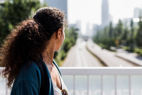 Young woman on bridge looking on street