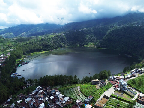 Aerial drone footage of Telaga Menjer, a beautiful volcanic lake located near the Dieng Plateau in Wonosobo, Central Java, Indonesia. Surrounded by lush green hills and spectacular mountain scenery