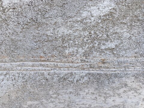 A close-up shot of a weathered concrete surface and rough textures.