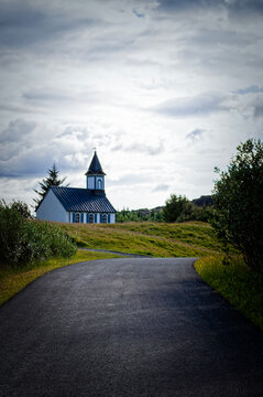 Iceland, Europe: the road leading to Thingvallakirkja, the Thingvellir Church consecrated in the 11th century in Thingvellir national park, home of the Althing, national Parliament since 930 AD