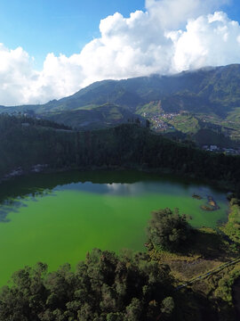 Aerial drone footage of Telaga Warna (Color Lake) on the Dieng Plateau, Central Java, Indonesia, captured during the late afternoon golden hour