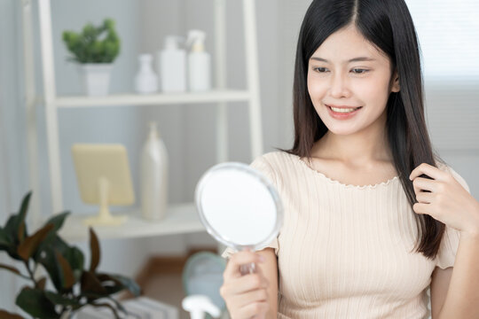 Beautiful Asian woman sit in front of a mirror. face of a healthy woman smile for good skin care. Advertisement for skin care, anti-wrinkle, baby face, whitening, moisturizer, tighten pores serum