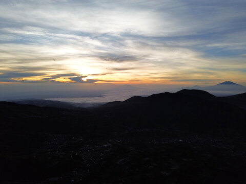 Aerial Drone View of Sunrise Between Mountain Ranges with Peaceful Morning Landscape	
