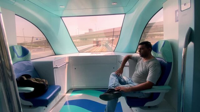 Young international tourists and expats ride the fully automated Dubai Metro Red Line to easily traverse the city.