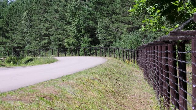 Road next to former Soviet border fence with barbed wire near Lazdijai, Lithuania