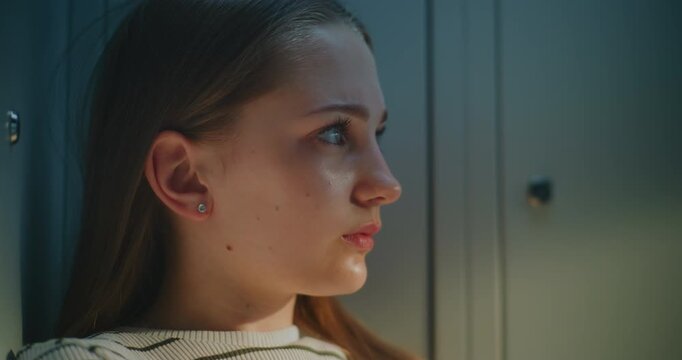 Teen Girl Resting by School Lockers During Break, Lost in Thought after Demanding Day. Concept of Mental Health, Personal Reflection, Emotional Awareness, Growing Up, Everyday Student Experiences.