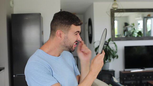 A 40 year old man observing his crow feet and forehead wrinkles using a mirror 