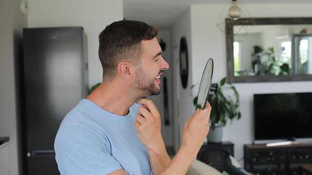 A 40 year old man observing his crow feet and forehead wrinkles using a mirror 