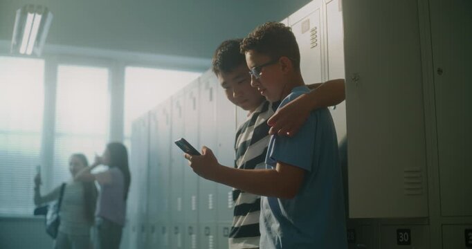 Friendly Teenage Classmates Relax by Lockers while One Shares Something Entertaining on Smartphone, Moment of Laughter and Connection. Youth Culture, School Community, and Healthy Peer Relationships.
