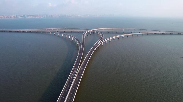 An aerial view of a multi-branched sea bridge with roadways spanning over calm water, connecting distant areas.