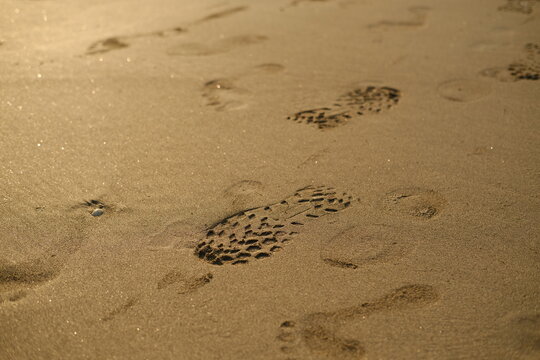 Trekking Boot Sole Tread Imprint in Golden Beach Sand, Outdoor Adventure and Travel Concept