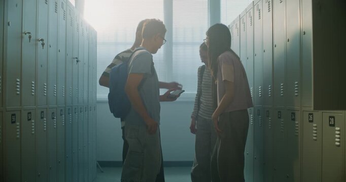Four School Classmates Stand Together in School Locker Area, Chatting and Reacting to Content on Shared Smartphone. Gen Z Lifestyle, Friendship, Digital Communication, and Everyday Social Interaction.