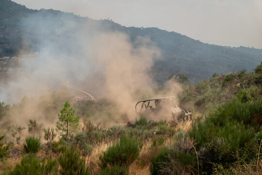 Bulldozer a operar num terreno acidentado para abrir aceiros ou faixa de conten&ccedil;&atilde;o e assim travar a propaga&ccedil;&atilde;o de um inc&ecirc;ndio florestal sob um fumo denso