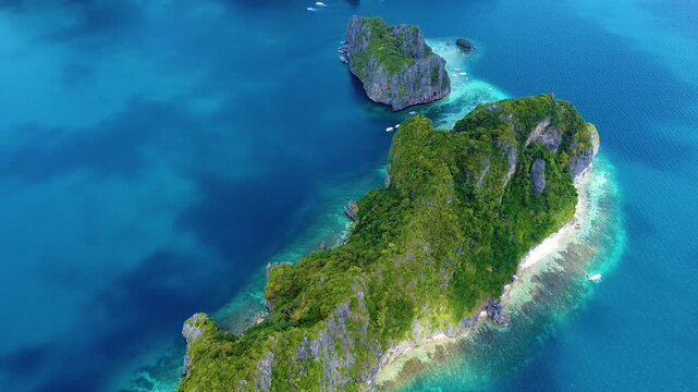 Aerial view of Inatula Island with lush green vegetation and limestone cliffs surrounded by turquoise waters in El Nido, Mimaropa, Philippines.