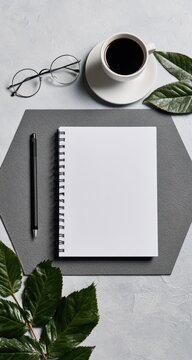 Overhead shot of a minimalist desk setup with coffee, notebook, and pen