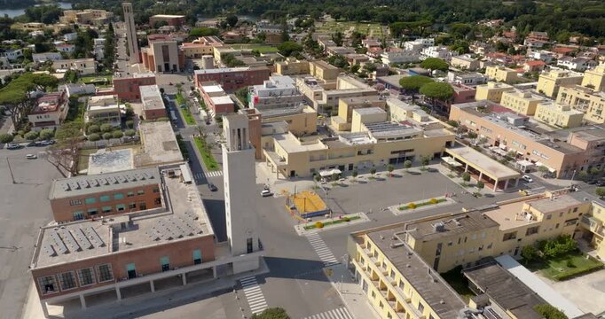 Aerial view of the town centre of Sabaudia, in the province of Latina, in Lazio, Italy, with the civic tower of the town hall and the rationalist buildings of the 1930s founding town, on a sunny day.