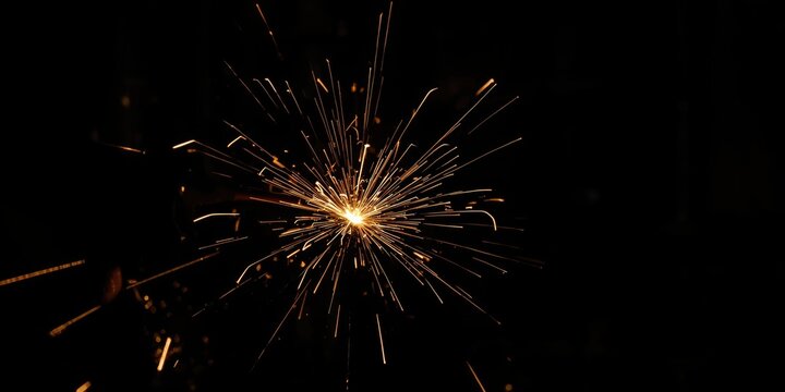 Sparkler Lighting Up in Dark Background with Radiating Sparks