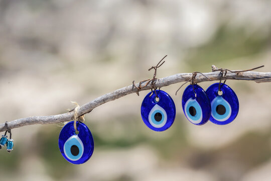 Traditional blue nazar evil eye charms hanging from a branch in Turkey
