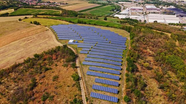 Aerial view of a solar farm with rows of photovoltaic panels situated in a rural landscape near Beocin, Vojvodina, Serbia.