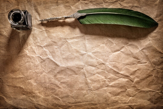 Quill pen and ink well on manuscript parchment paper