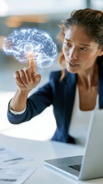 Woman interacting with a glowing digital brain hologram while working at a desk