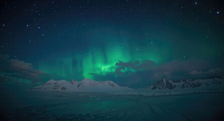 Fototapeta premium Aurora Borealis Illuminating Snowy Mountains Under Starry Sky at Night