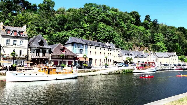 Kayakers paddling on a river next to a charming historic town Dinan in France. Perfect for travel blogs, vacation brochures, and editorial tourism articles.