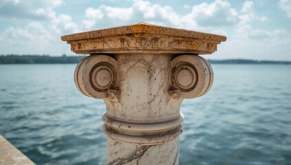 Fototapeta premium Elegant Marble Column by Water with Calm Reflections and Partly Cloudy Sky