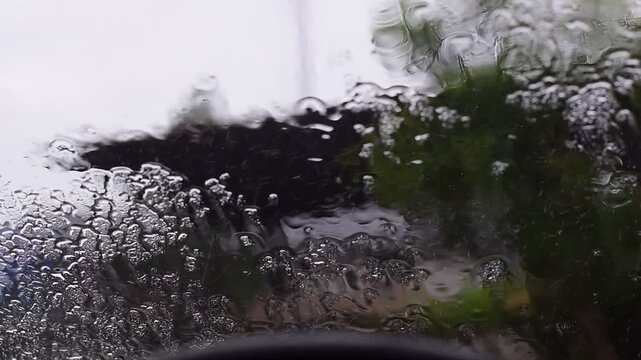 Car windshield with rain drops and frameless wiper blade,Traffic Jam with raining in evening day in the city,Drops of water on the car after rainy,outside car,Raindrops falling on a glass