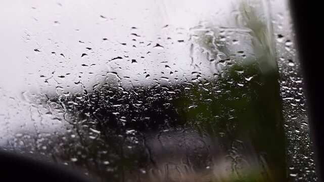 Car windshield with rain drops and frameless wiper blade,Traffic Jam with raining in evening day in the city,Drops of water on the car after rainy,outside car,Raindrops falling on a glass