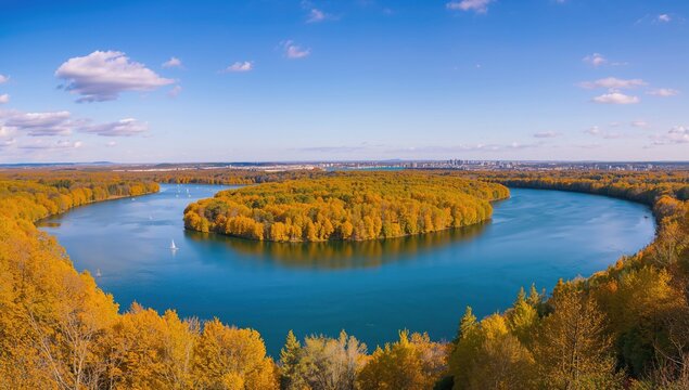 Autumn Landscape with a Curved River Surrounded by Colorful Trees and Blue Sky