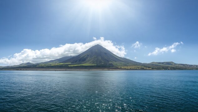 Mountain Surrounded by Water Under a Bright Sun in Clear Sky