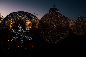 Obraz premium Bright Christmas lights on decorations at sunset during a holiday display in a public garden