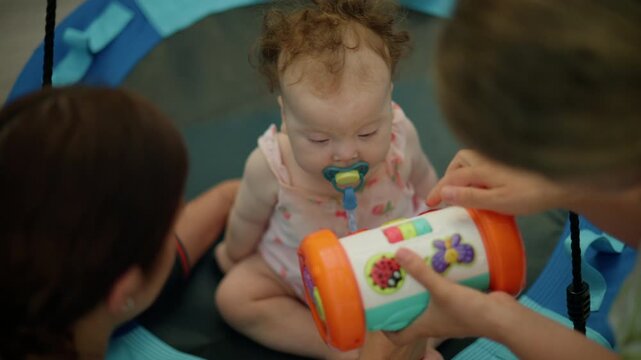 Infant with a pacifier playing with an educational toy during a developmental therapy session, focusing on early learning and care
