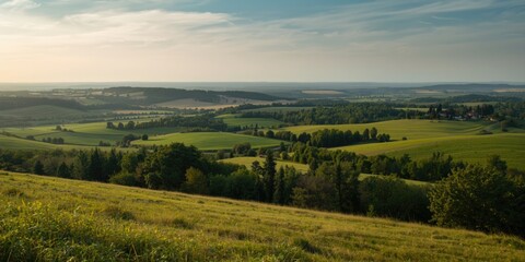 Obraz premium Lush Green Countryside Landscape with Rolling Hills Under Clear Sky