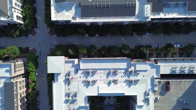 Residential apartment rooftops adjoin tree lined streetscapes along Olympus Boulevard within DFW area. Courtyard recreation amenities flank structured multi tier garages, Coppell, Texas
