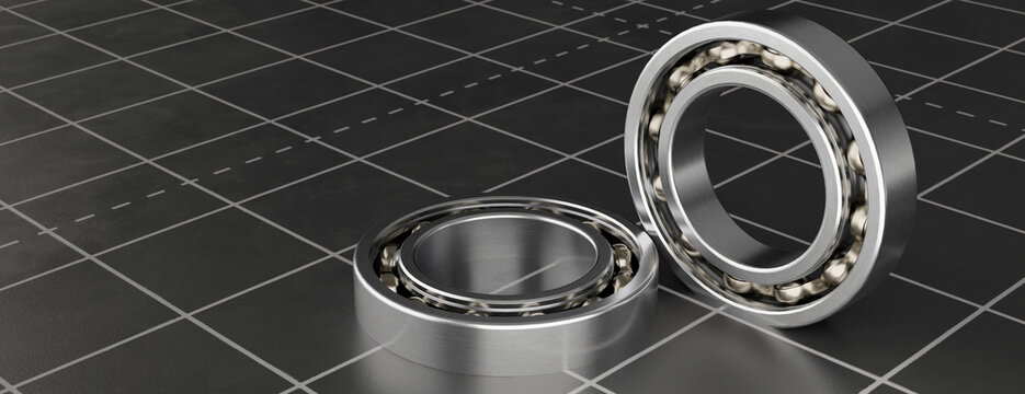 Close-up view of two shiny metal ball bearings on a dark grid surface