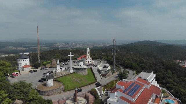 Aerial view of Capela de Sao Felix and Santuario da Senhora da Saude de Laundos with surrounding hills and parking area in Laundos, Porto, Portugal.