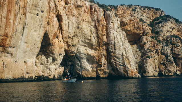 boat by the cliffs at sunset in Sardinia